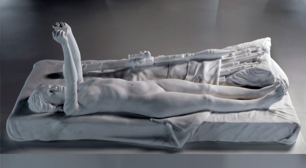 Figura en una cama con cámara y armas.jpg